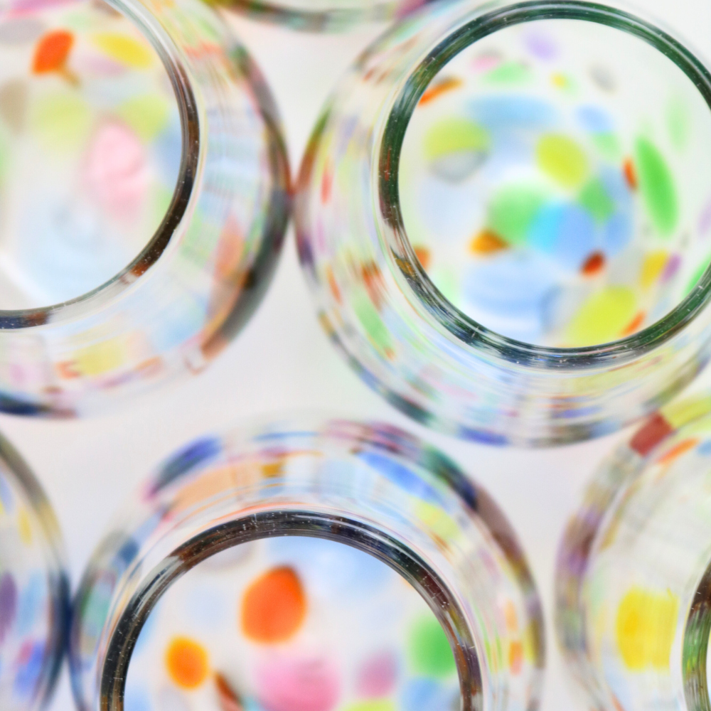 Top down view of stemless wine glasses with colourful bottoms