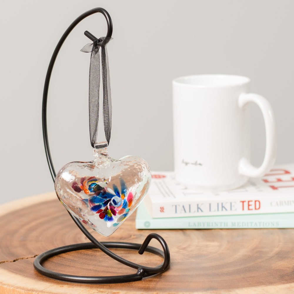 Heart of Wonder on a Small Curved Single Ornament Holder on a wooden table with a white mug on a stack of books