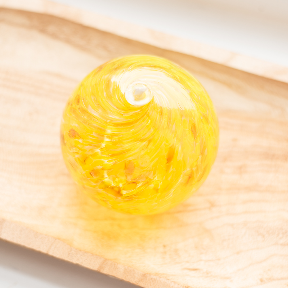 Yellow oil lamp on a wood tray