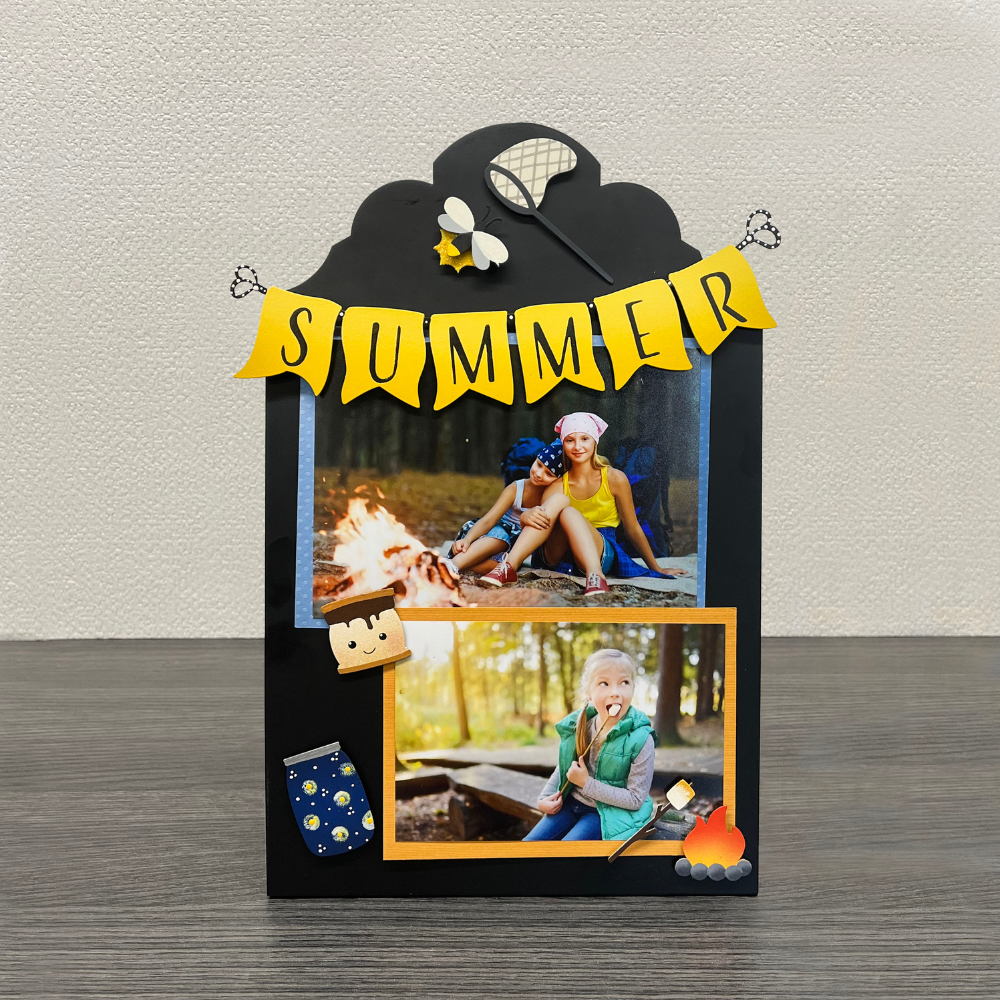 A black easel decorated for summer with bonfire photos. 