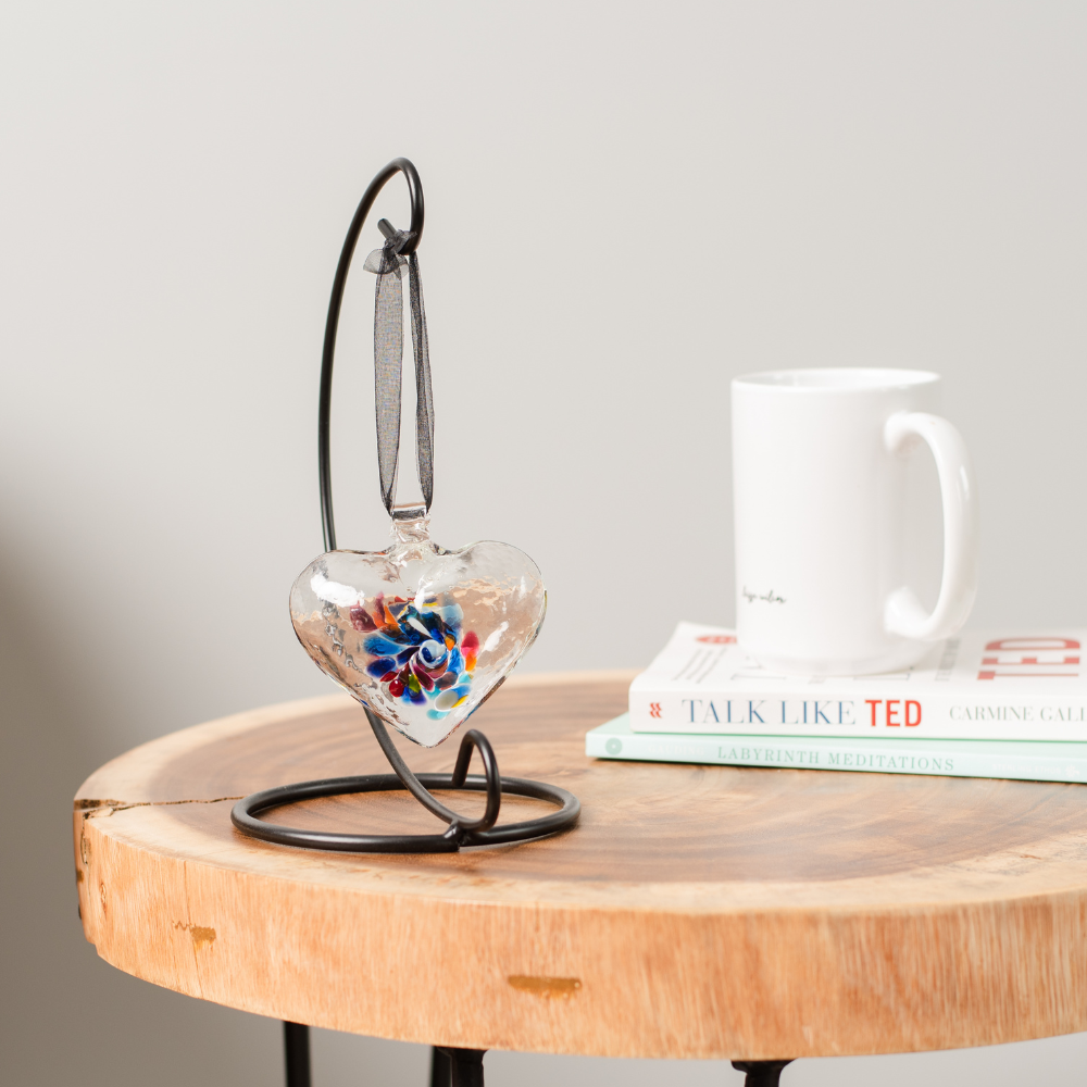 Heart of Wonder on a Small Curved Single Ornament Holder. Displayed on an end table beside a white coffee cup.