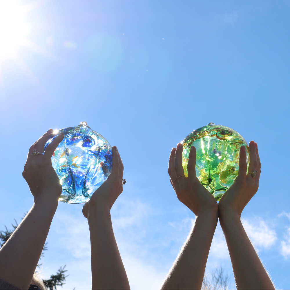 Water Orb in two hands, Earth Orb in two hands with blue sky in the background