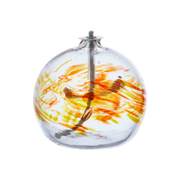 Flat-bottomed glass orb with a wick with orange and yellow coloured glass around the middle and horizontal webbing on a transparent background.